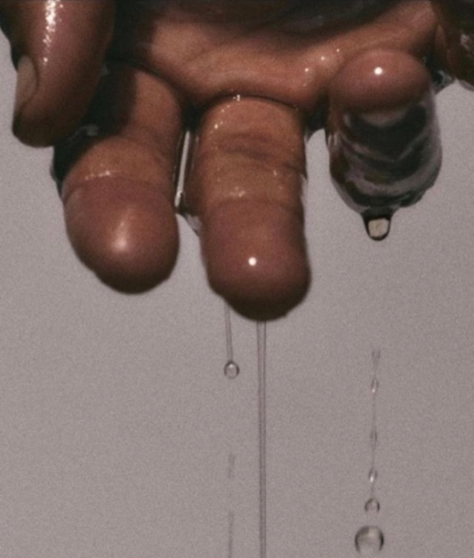 Image by @feaverish. Image of a hand suggestively dripping a clear liquid.